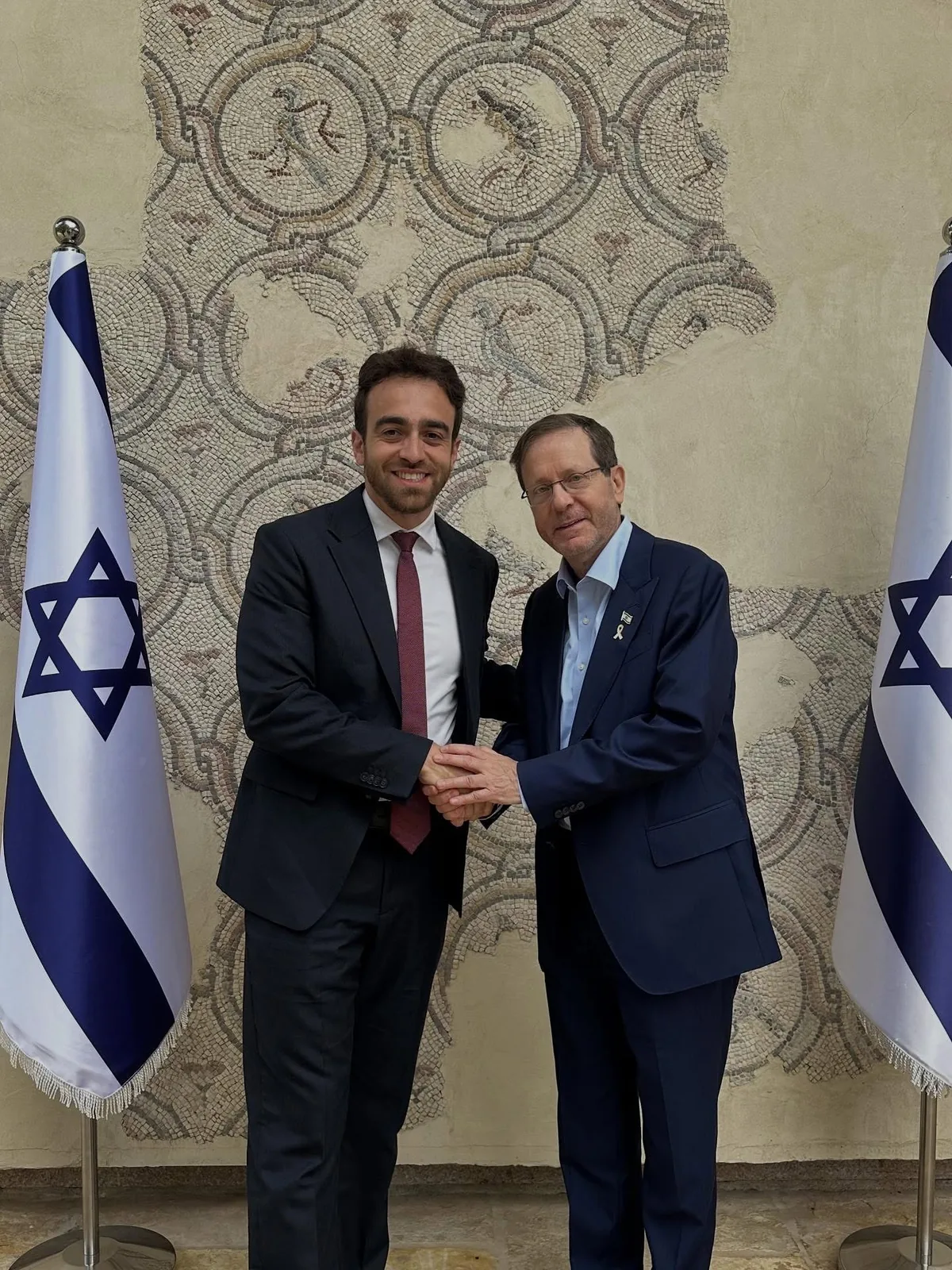 Henrique Krigner cumprimenta Isaac Herzog, presidente de Israel, entre duas bandeiras israelenses
